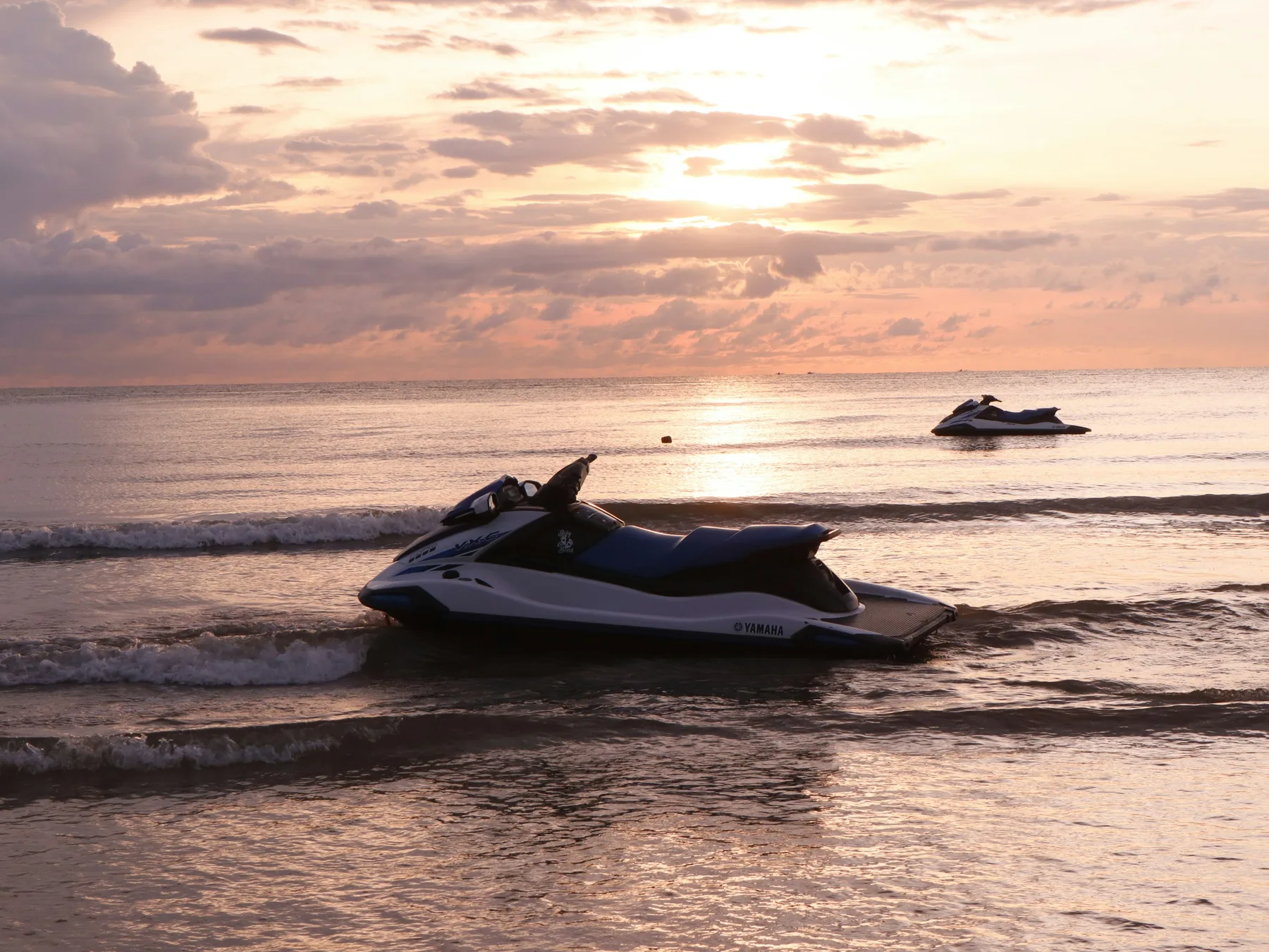 Jet skis on the water at sunset at Tanjung Aru, Kota Kinabalu; illustrative stock image, not Alyna's equipment or tour.